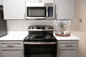 granite countertops, stainless steel appliances, and subway tile backsplash at  Addison at Collierville Apartments in Collierville TN 38017